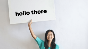 girl holding up a sign that says hello there
